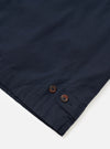A detailed close-up shot of the Navy Micro Canvas Warmus Jacket set on a white background, highlighting the front buttoning, collar structure, chest welt pocket, and fine dark navy blue canvas fabric texture.