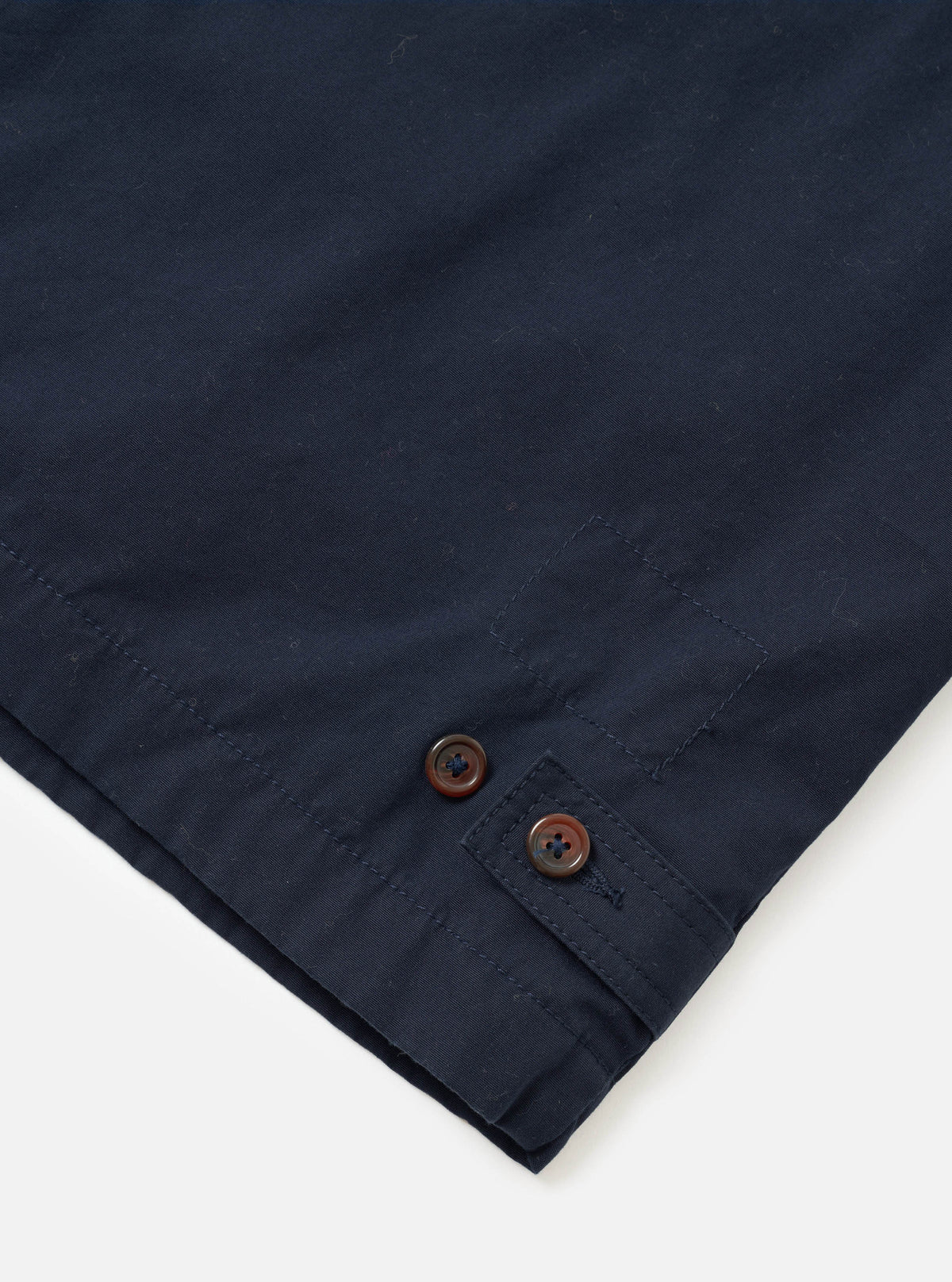 A detailed close-up shot of the Navy Micro Canvas Warmus Jacket set on a white background, highlighting the front buttoning, collar structure, chest welt pocket, and fine dark navy blue canvas fabric texture.