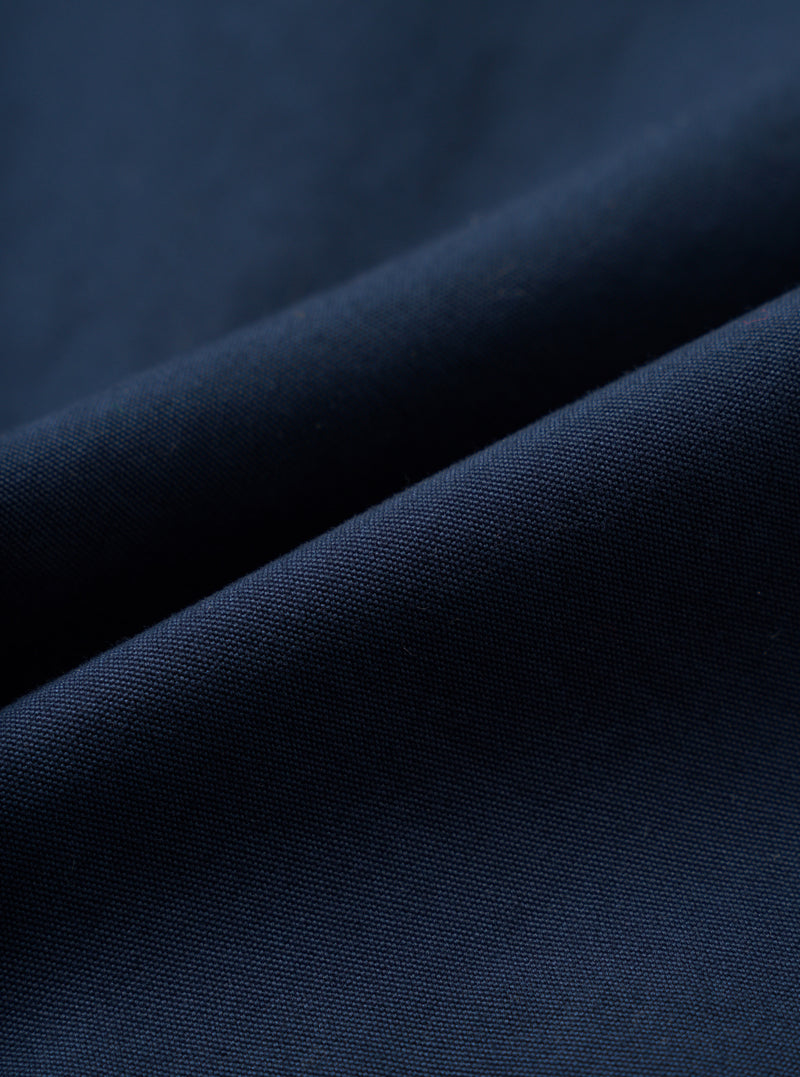 A detailed fabric swatch photograph of the Navy Micro Canvas Oxford Pant displayed on a plain white background, showcasing the rich navy blue color and smooth micro-canvas texture of the cotton fabric.