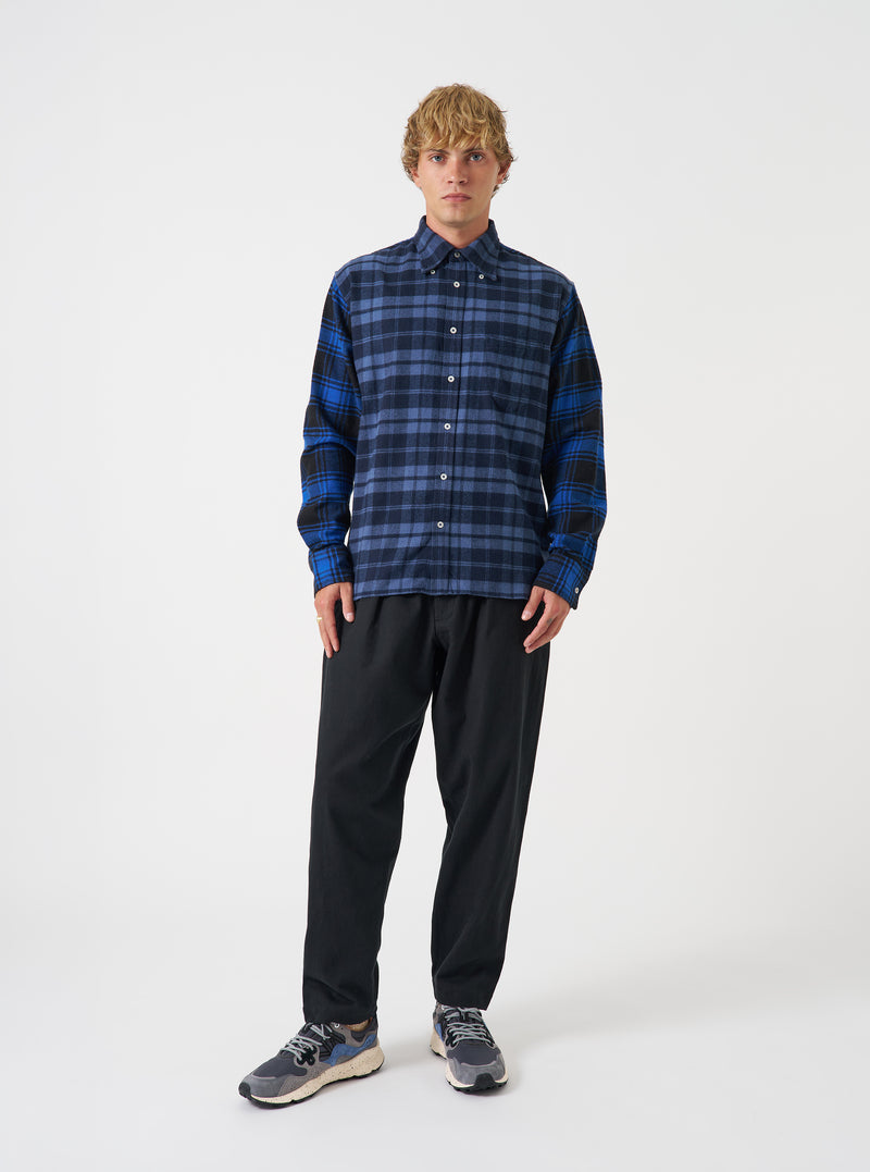 A full-length studio photograph of a model wearing the Navy/Blue Brush Panel Check 1 Lazy Day Shirt against a plain backdrop. The shot showcases the relaxed button-down fit, check pattern, collar detail, and chest pocket placement.