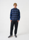A full-length studio photograph of a model wearing the Navy/Blue Brush Panel Check 1 Lazy Day Shirt against a plain backdrop. The shot showcases the relaxed button-down fit, check pattern, collar detail, and chest pocket placement.
