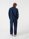 Back view of a model wearing the Navy Patchwork Twill Three Button Jacket against a plain white background, emphasizing the structured shoulder seam line and navy cotton twill paneling.