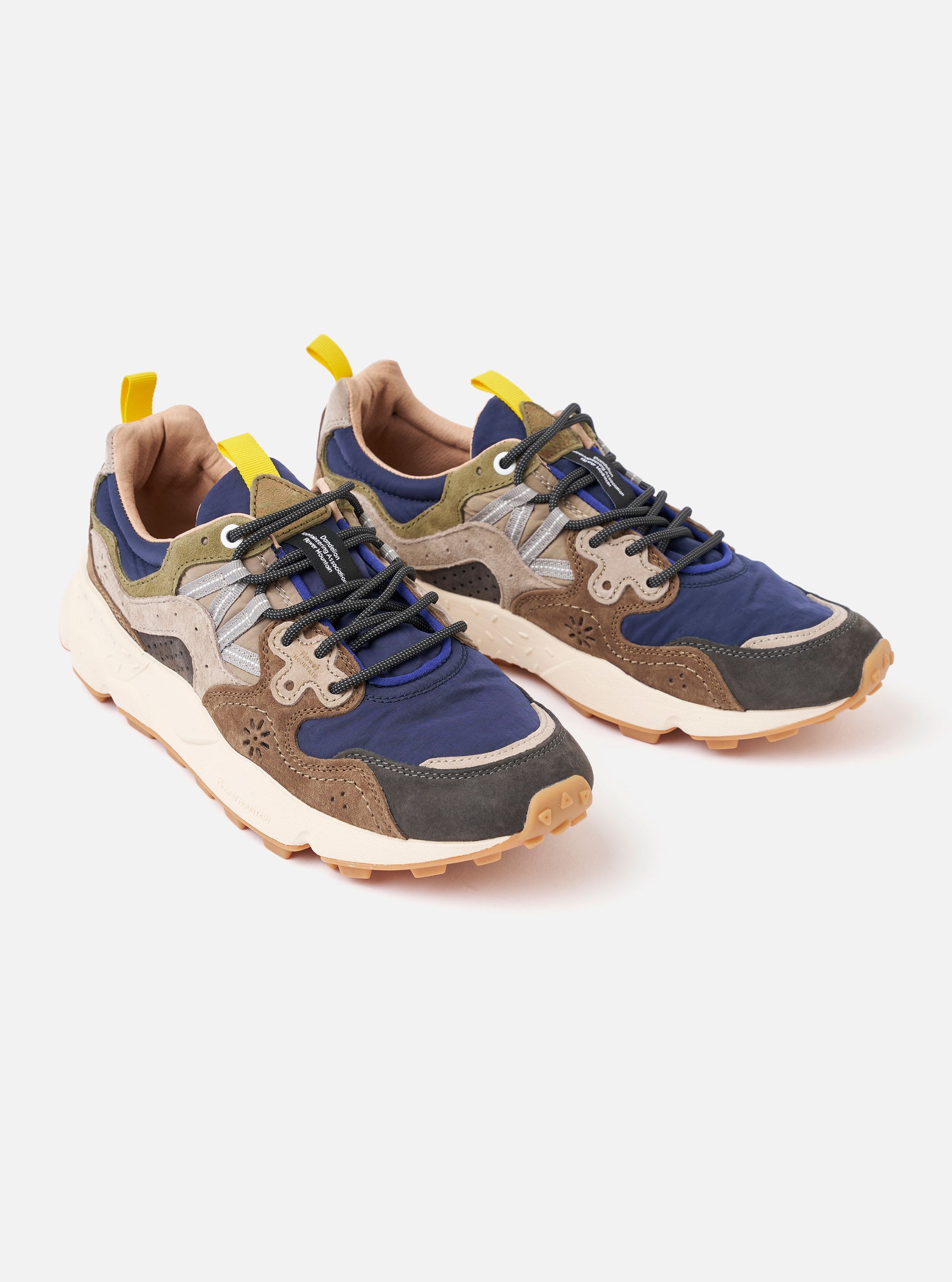 The Flower Mountain Dark Grey/Brown Suede/Nylon Yamano 3 Man is shown from a rear angle against a plain white background. The sneaker features a chunky, light-colored rubber sole with a toothed tread and a pull tab on the heel. The upper is constructed from dark grey technical nylon with brown suede overlays and intricate decorative stitching.
