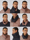 A model showcases the TAION x Universal Works Reversible Black Military Line Neck Warmer. The neck warmer is reversible, featuring black quilted nylon on one side and a brown houndstooth pattern on the other.