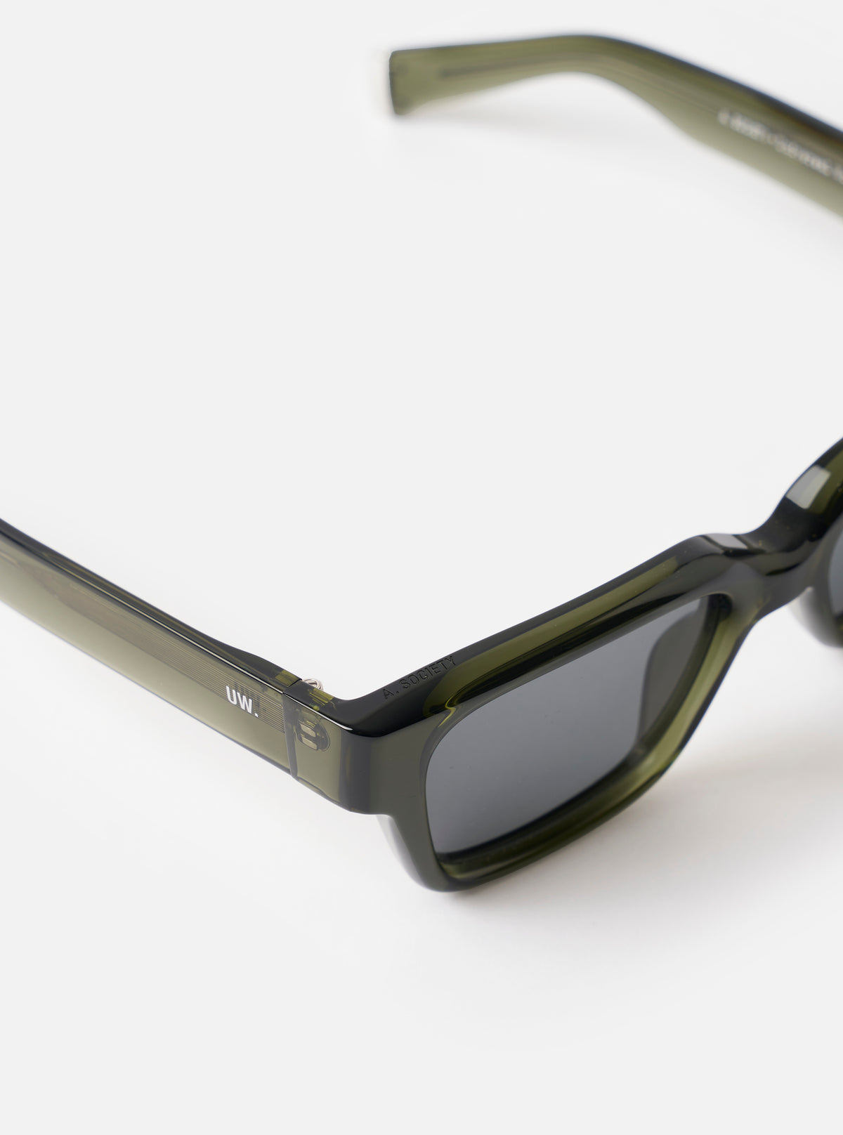 Side profile view of the A. SOCIETY x Universal Works Olive Hollywood Sunglasses set against a crisp white backdrop, showing the temple arms, sturdy hinges, and polished olive frame shape clearly.