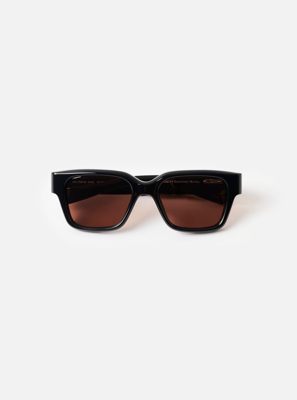 Front view product shot of the A. SOCIETY x Universal Works Black Hollywood Sunglasses set against a plain white backdrop, highlighting the thick black frame and dark tinted lenses.