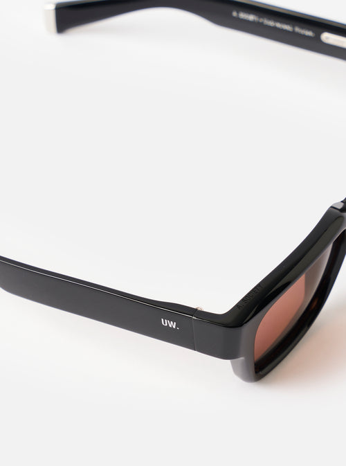 Side profile view of the A. SOCIETY x Universal Works Black Hollywood Sunglasses on a clean white background, displaying the sturdy temple arms, sleek hinge detail, and black acetate frame.