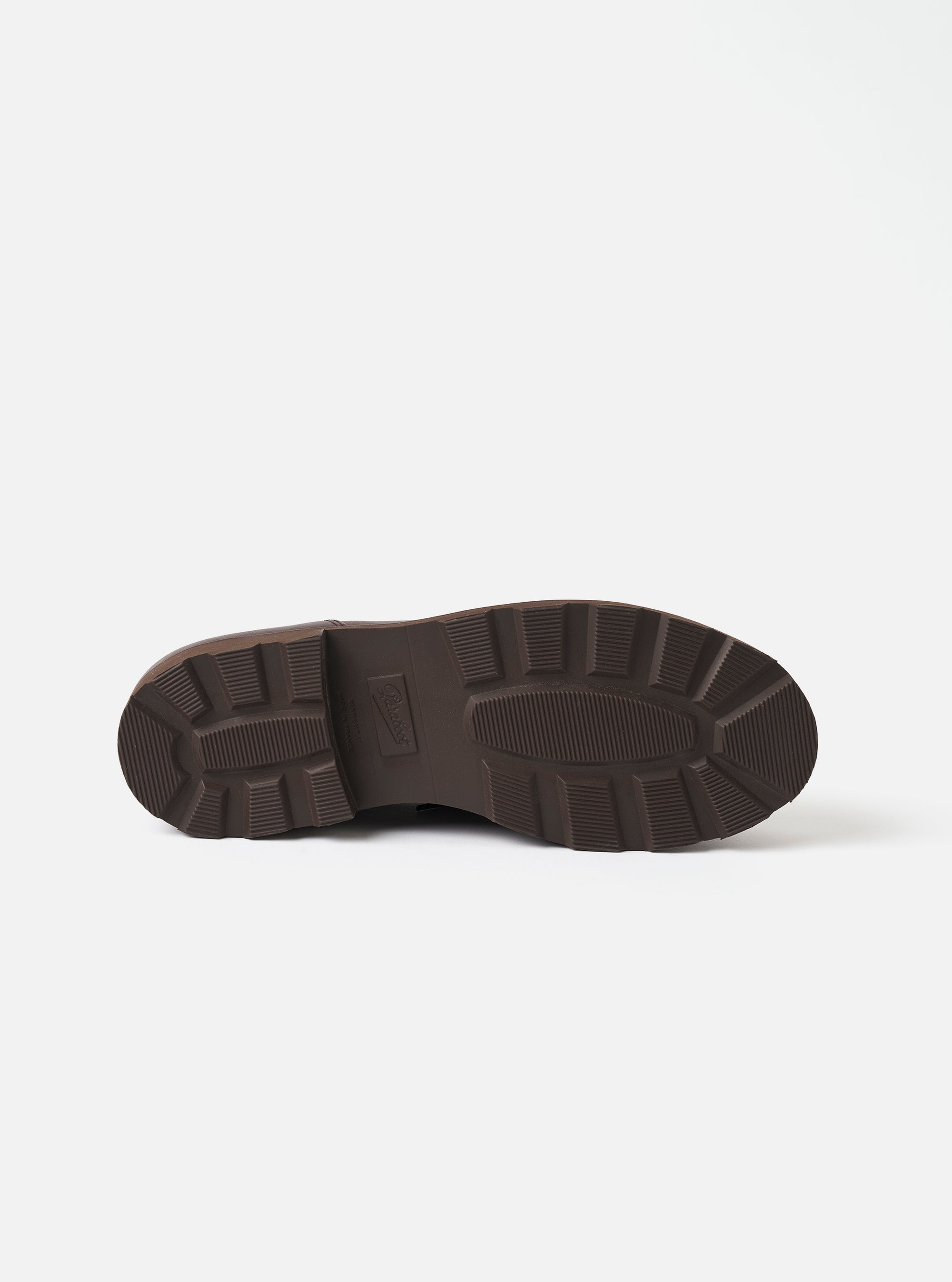 Underside of the Paraboot Café leather Michael Marche II, showing the dark brown rubber outsole. The chunky lug sole features deep ribbed tread blocks across the forefoot and heel, with a smooth central oval zone and a small embossed Paraboot logo. Shot on a plain white studio backdrop.