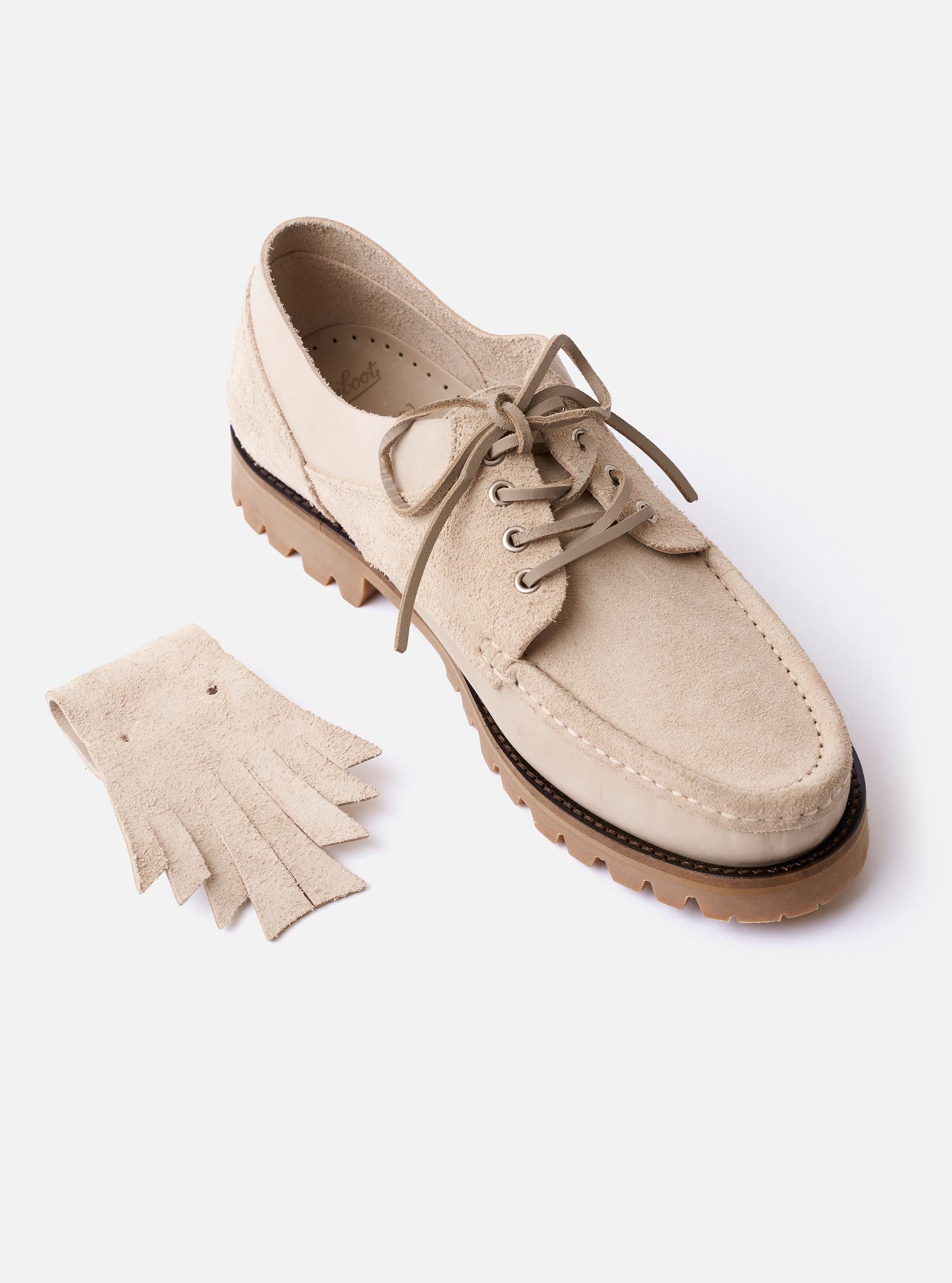 The Paraboot x Universal Works Thiers/Jannu in Sand Leather/Suede is shown as a flat lay from a side angle against a plain white background. The shoe features a combination of smooth sand-colored leather and textured suede panels, a chunky off-white rubber sole, and a decorative removable kiltie fringe over the laces.