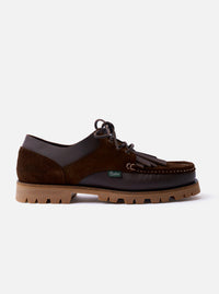 The Paraboot x Universal Works Thiers/Jannu in Café Leather/Suede is shown as a flat lay against a plain white background. The shoe features a combination of smooth café brown leather and textured suede panels, a four-eyelet lace-up closure, and a removable kiltie fringe. It is finished with a chunky vulcanized natural rubber sole and piped seams.