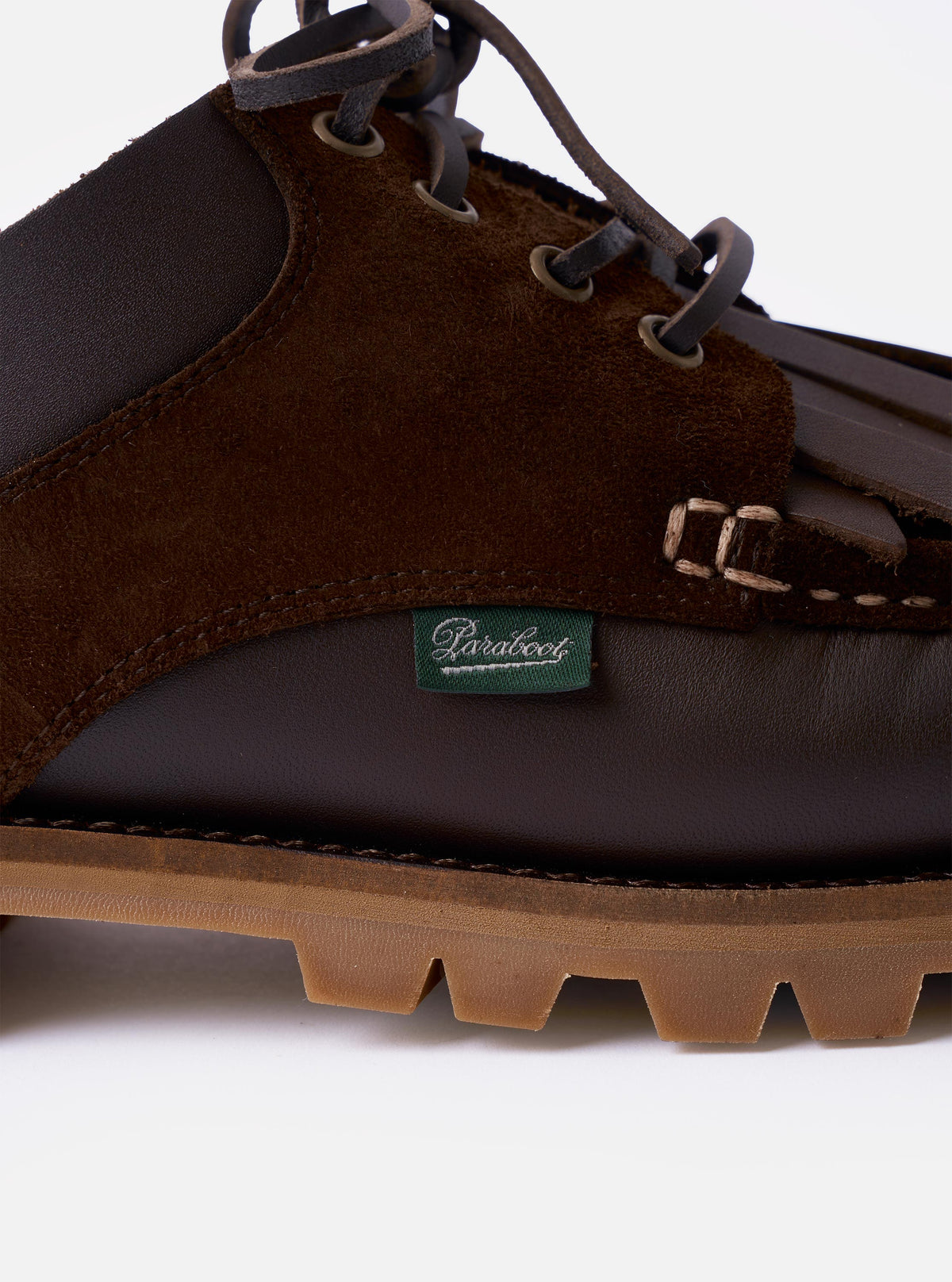 The Paraboot x Universal Works Thiers/Jannu in Café Leather/Suede is shown from a rear angle as a flat lay against a plain white background. The image highlights the dark brown leather and suede construction, the piped seams, and the thick, textured rubber sole.