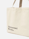 Close-up of an Ecru Cotton Canvas Tote Bag on a white background. The bag features black text and matching handles.