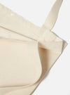 Close-up of an Ecru Cotton Canvas Tote Bag on a white background. The bag is folded, showing the texture of the cotton and the straps.