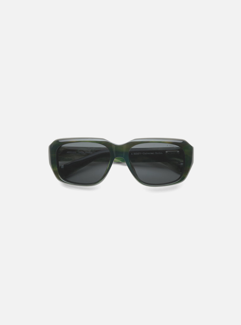 A. SOCIETY x Universal Works Green Aberdeen Sunglasses on a white surface. Green havana frame with dark lenses. 