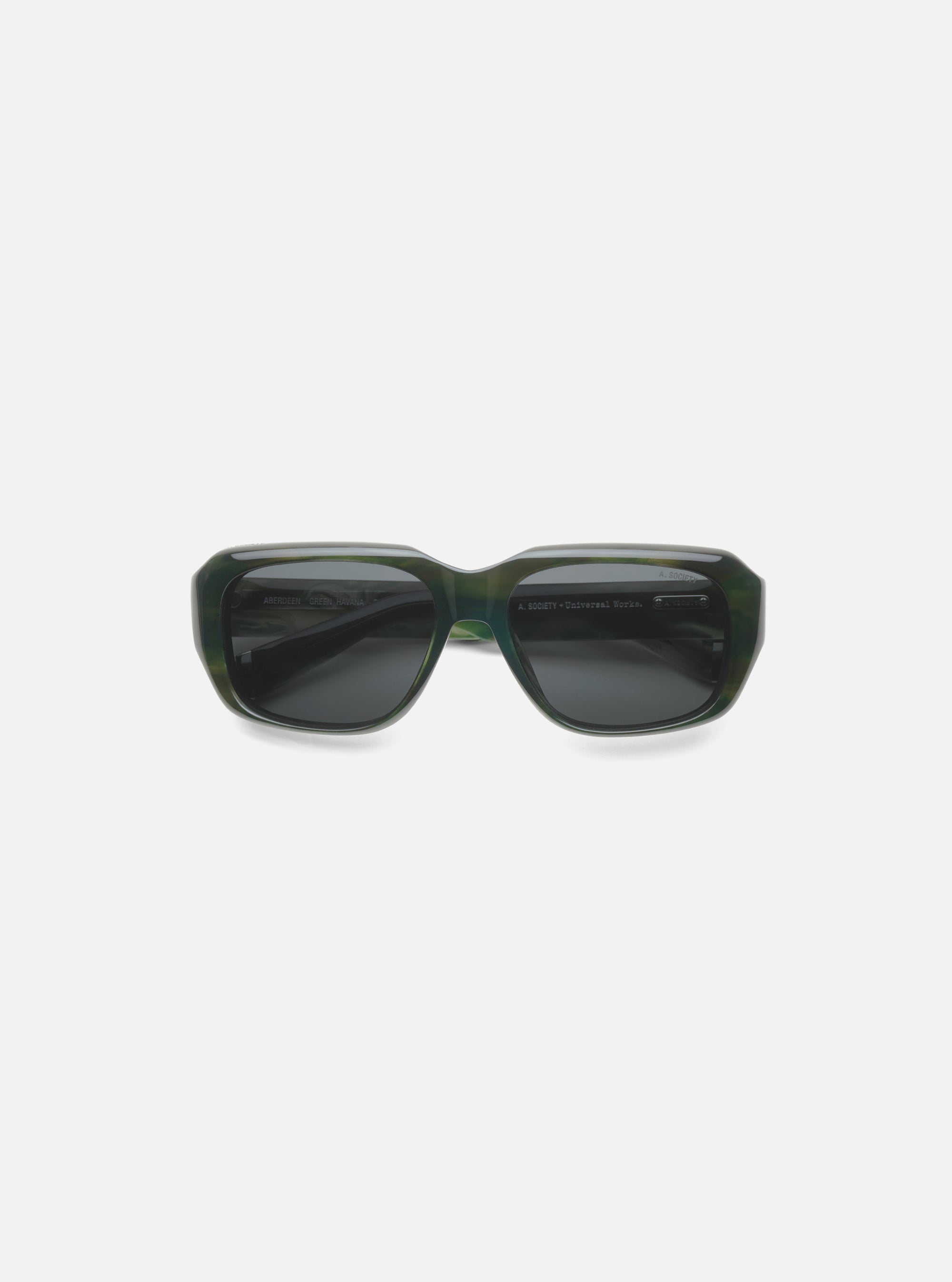 A. SOCIETY x Universal Works Green Aberdeen Sunglasses on a white surface. Green havana frame with dark lenses. 
