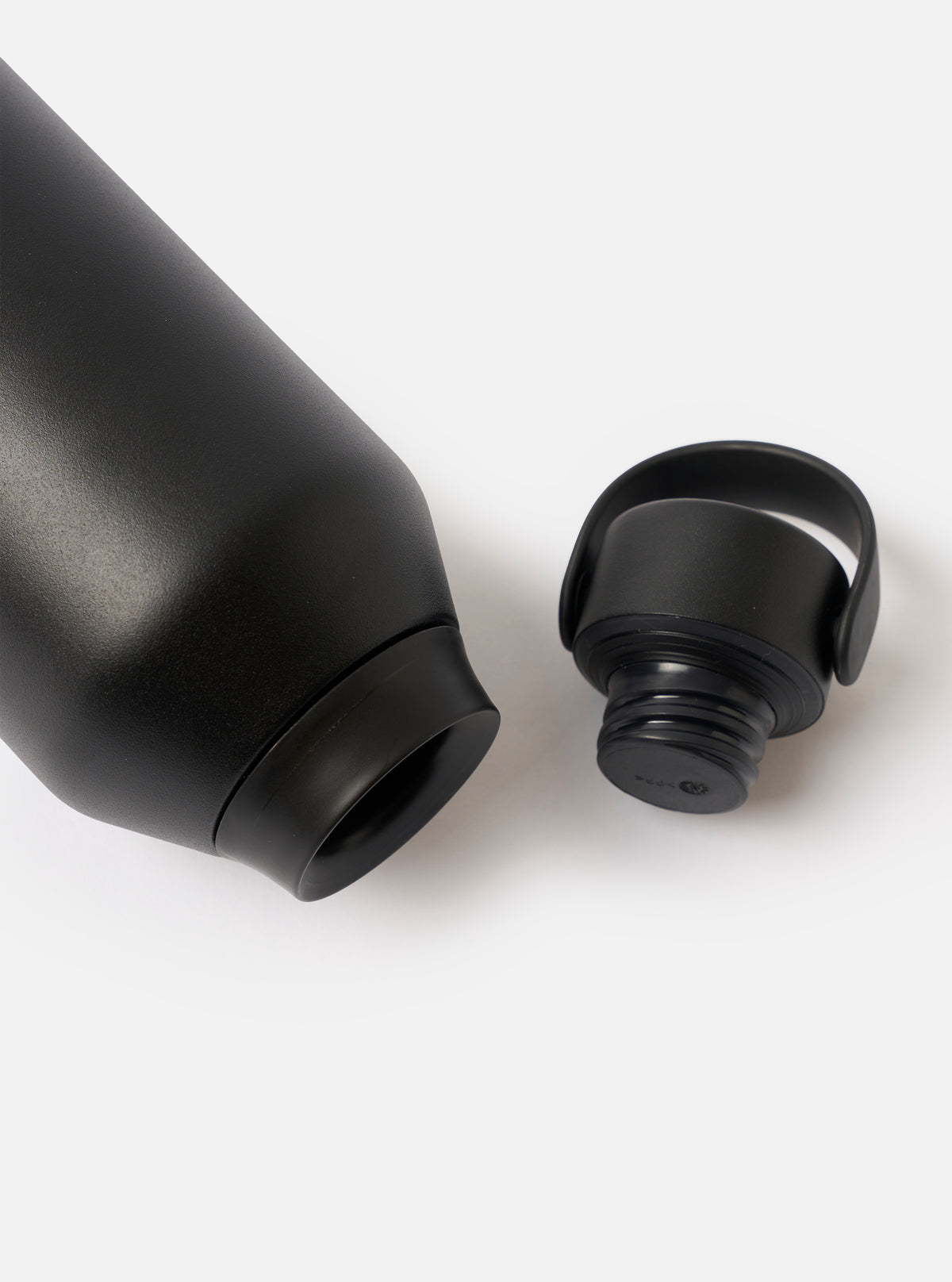 Angled view of the Chilly's x Universal Works Onyx Series 3 500ml Water Bottle set against a neutral white backdrop, focusing on the dark onyx finish and dual-branded logo detailing.