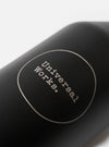 Studio product photograph showing the Chilly's x Universal Works Onyx Series 3 500ml Water Bottle positioned on a white surface, highlighting its carry loop lid and sleek bottle shape.
