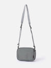 The F/CE. Foliage Green Recycled Nylon 420 re/cor Holiday Sacoche is shown from a rear angle as a flat lay against a plain white background. The image highlights the adjustable webbing shoulder strap with a plastic buckle and the clean back panel of the small, foliage green bag.