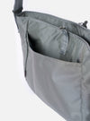 The F/CE.® Foliage Green Recycled Nylon 420 re/cor Courier Shoulder Bag is shown from a rear angle as a flat lay against a plain white background. The image highlights the adjustable messenger-style shoulder strap with a one-touch buckle and the structured, padded back panel. The foliage green recycled nylon fabric has a smooth, technical finish.