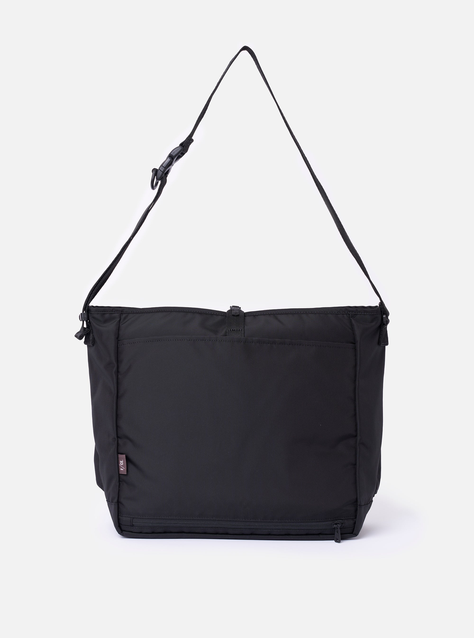 The F/CE. Black Recycled Nylon 420 re/cor Courier Shoulder Bag is shown from the back as a flat lay against a plain white background. The image highlights the wide, adjustable messenger-style shoulder strap and the smooth, technical texture of the black recycled nylon fabric.
