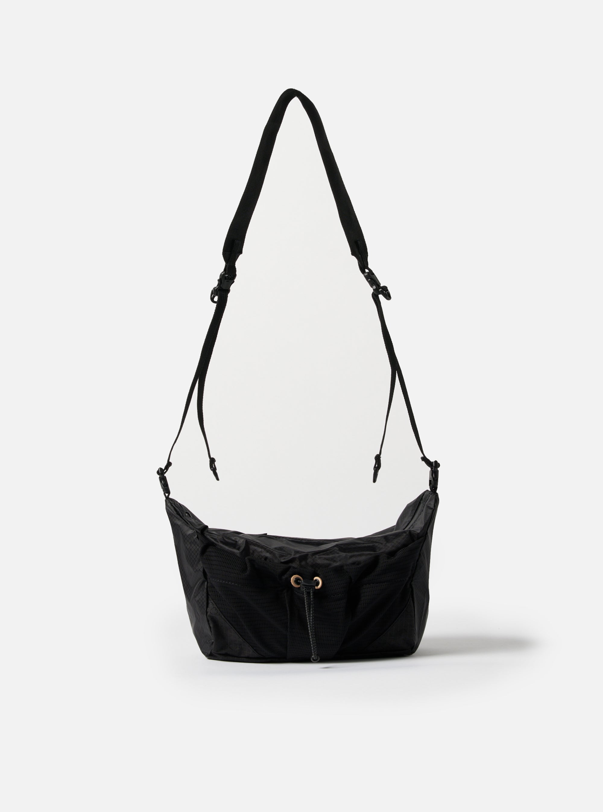 The F/CE.® Black Nylon Cordura Sil Sacoche bag hangs against a white backdrop. The black nylon bag features a drawstring closure and adjustable straps.