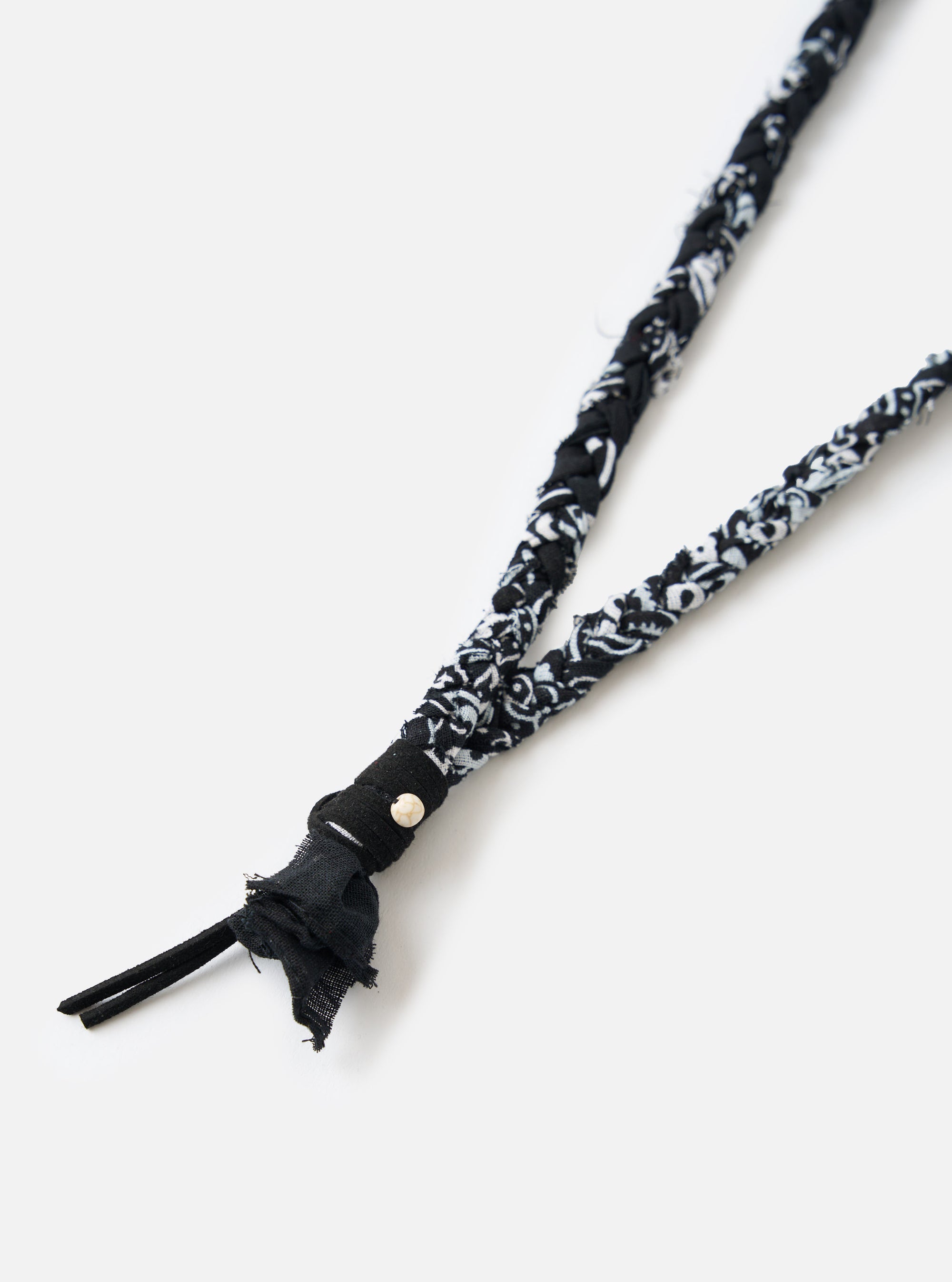 Close-up of the Hanami of Rome Black/Black Leather/White Turquoise Bead Bandana Necklace No.48 on a white surface. The necklace features braided black and white bandana fabric and a turquoise bead.