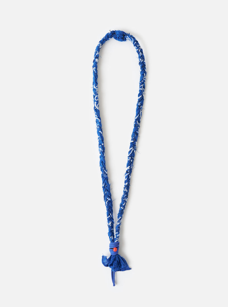 Hanami of Rome Blue Royal Leather/Peach Bead Bandana Necklace No.55 on a white background. The necklace is blue and white braided material with a peach bead.