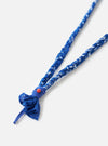 Close-up of the Hanami of Rome Blue Royal Leather/Peach Bead Bandana Necklace No.55 on a white background. The necklace features a blue and white braided band and a peach-colored bead.