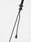 Close-up of the black strap and toggle of the master-piece x Universal Works Black Recycled Tech Canvas Sacoche against a white backdrop.