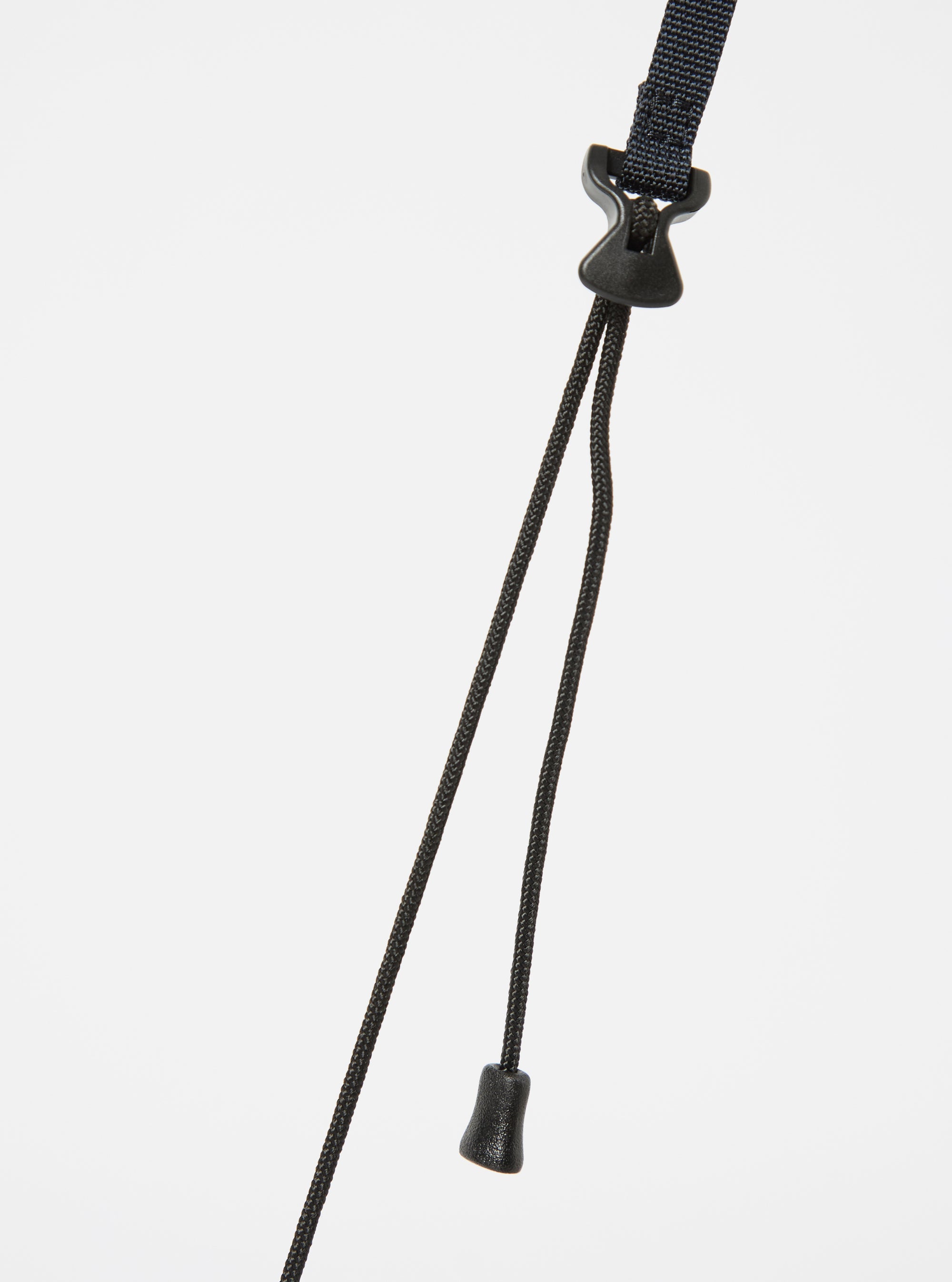 Close-up of the black strap and toggle of the master-piece x Universal Works Black Recycled Tech Canvas Sacoche against a white backdrop.
