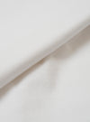 A close-up fabric swatch of the master-piece x Universal Works White Single Jersey Print Tee shows the off-white cotton material. The image focuses on the fine, smooth texture of the single jersey knit.