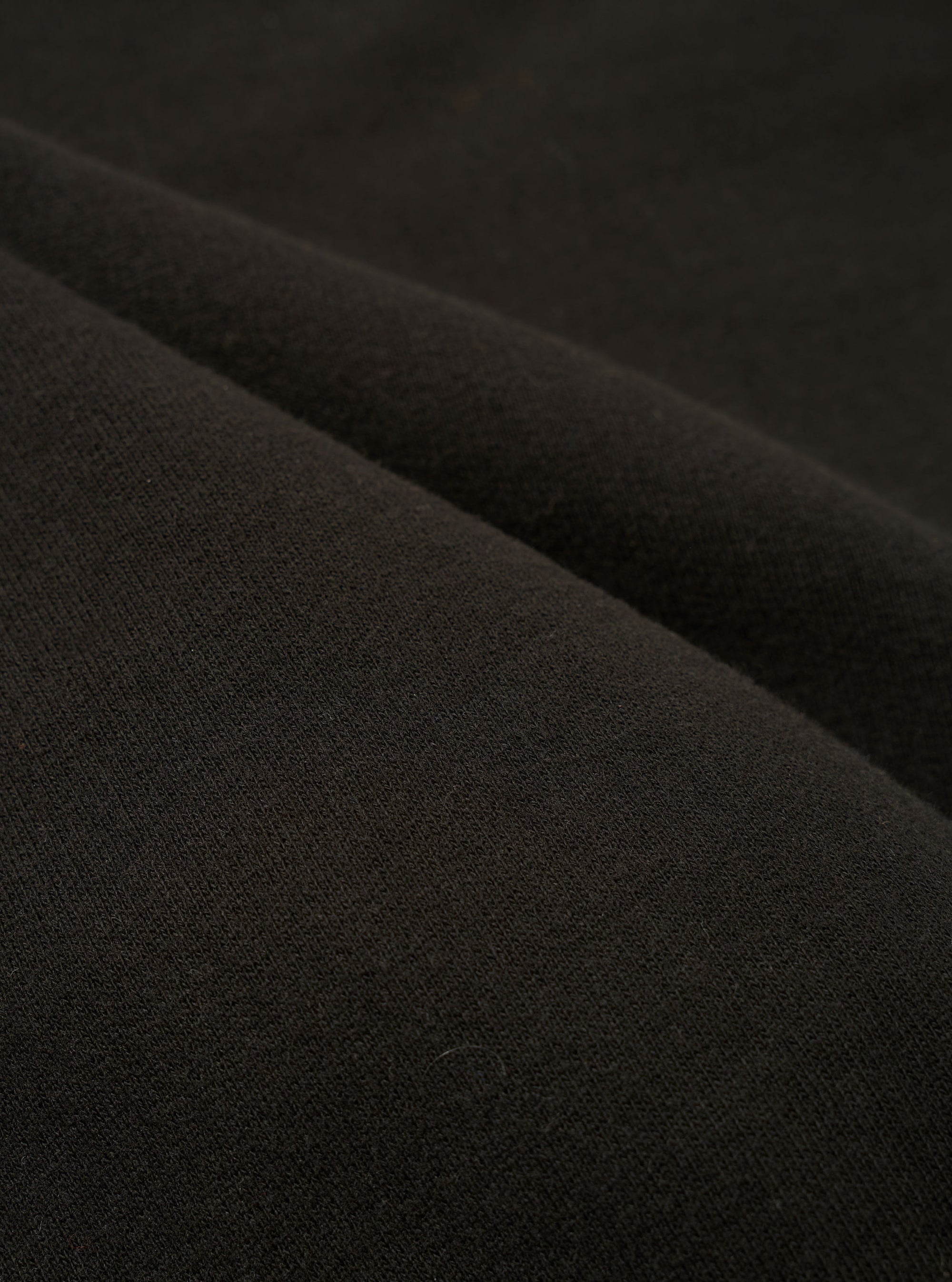 The master-piece x Universal Works Black Brush Back Sweat S/S Billy Sweat is shown as a flat lay against a white background. This short-sleeve sweatshirt features a crew neck, ribbed collar, and ribbed cuffs. A prominent design detail is the contrasting white side-seam zips located at the hem on both sides.