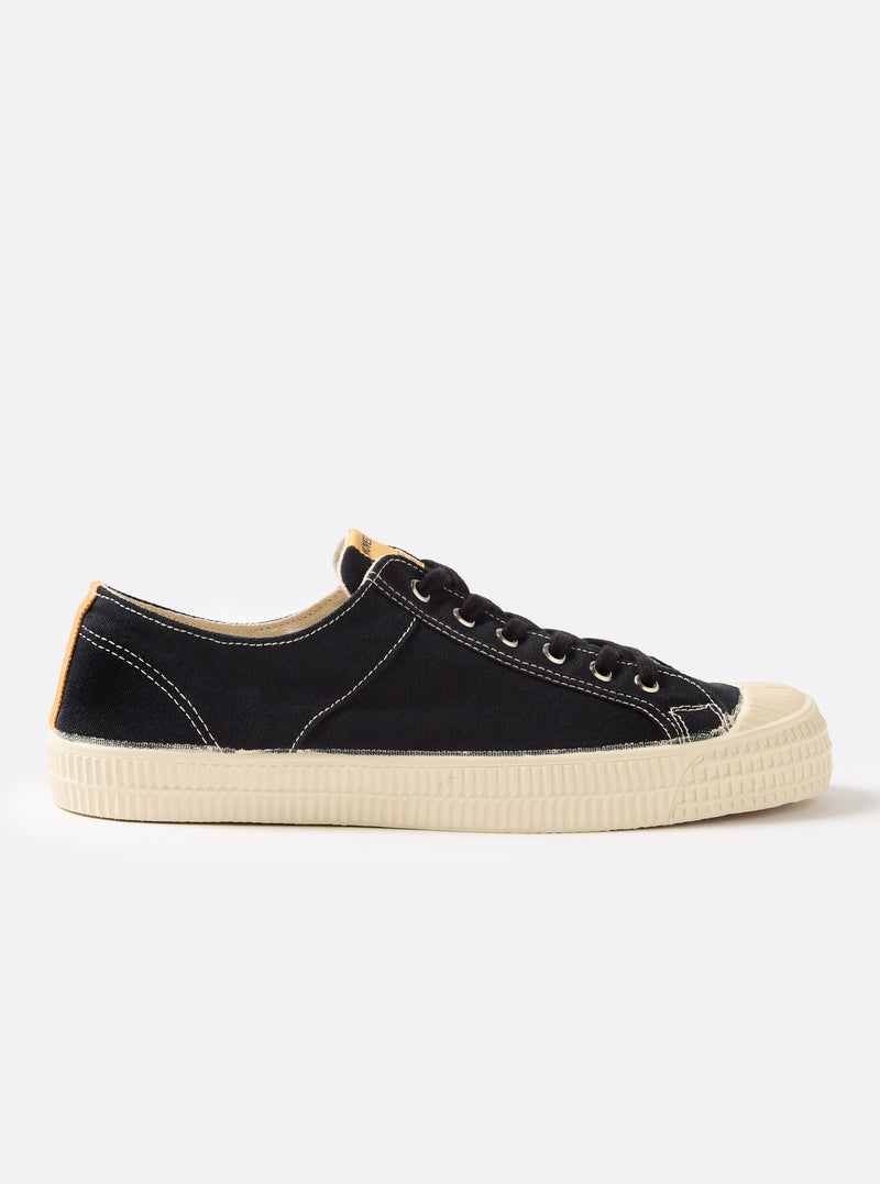 Side view of the Novesta for Universal Works Black Canvas Star Master shoe on a white background. The shoe is black canvas with a cream-colored sole.