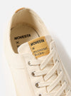 Close-up of the Novesta for Universal Works Ecru Canvas Star Master shoe. The ecru canvas and laces are visible, with a branded tongue. Shot on a white background.