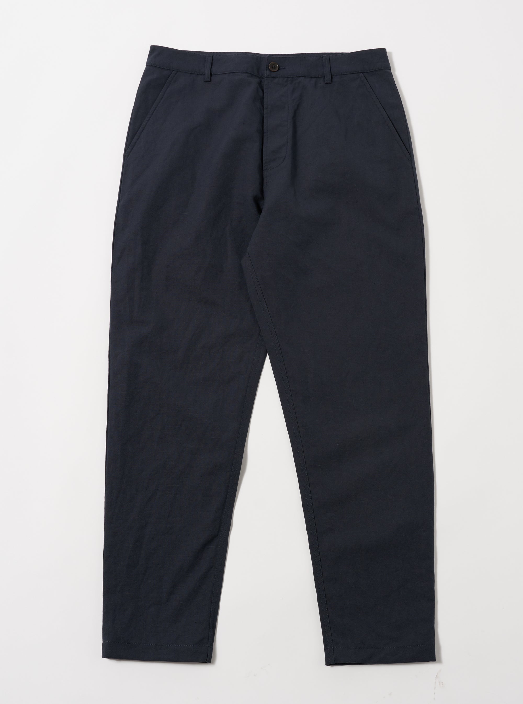 The Navy Linen Slub Weave Military Chino laid on a white surface. The pants are a dark navy color and made of a textured linen material. 