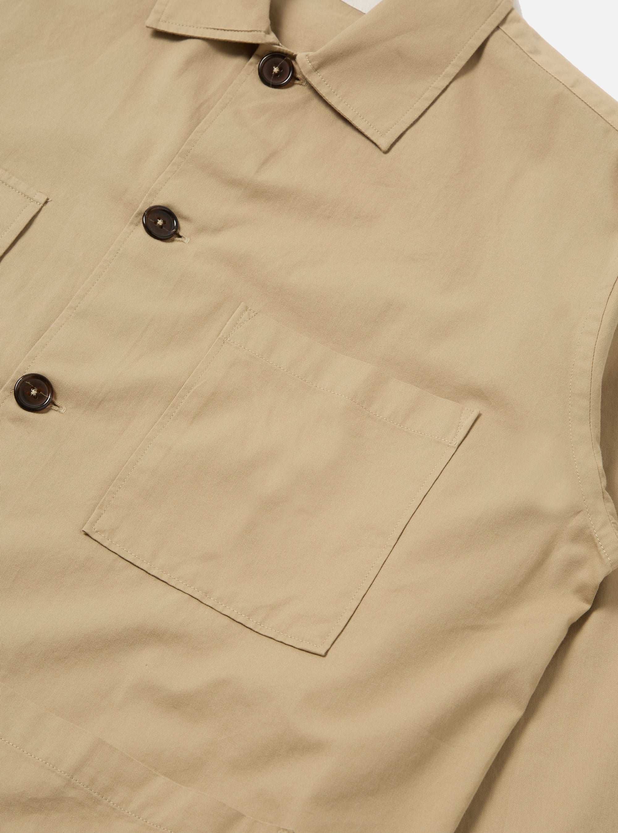Close-up of the Sand Military Cotton Dockside Overshirt, showcasing its sand color, cotton material, button details, and pocket. Shot on a plain white background.