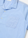 Close-up of the Blue Vila Stripes Sal Road Shirt on a white surface. The shirt is light blue with white stripes and has a pocket. The shirt is buttoned.