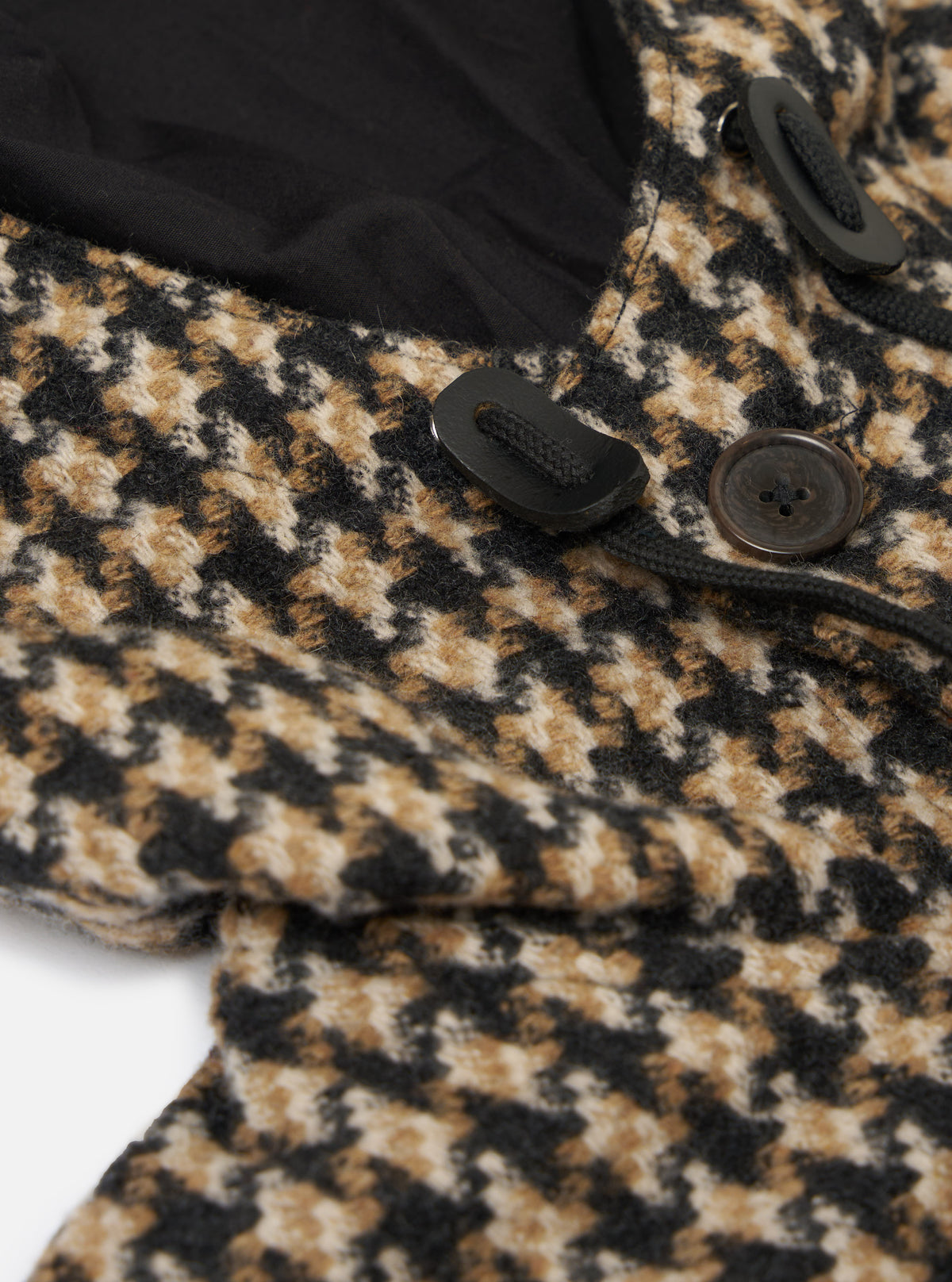 Close-up of the Sand Cortina Tweed Boston Parka showing the tweed fabric, black lining, toggle and button closures on a white background.