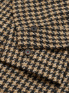 Close-up of the Sand Cortina Tweed Boston Parka, showcasing its tweed texture and button details. The background is a plain surface.