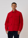 A model poses in front of a white backdrop, wearing the Embroidered Red Mowbray Military Fatigue Jacket. The jacket is a vibrant red with multiple pockets.