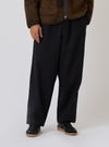 A model wears the Black Organic Canvas Dutch Pant, a loose-fitting black pant. Shot in studio on a white backdrop.