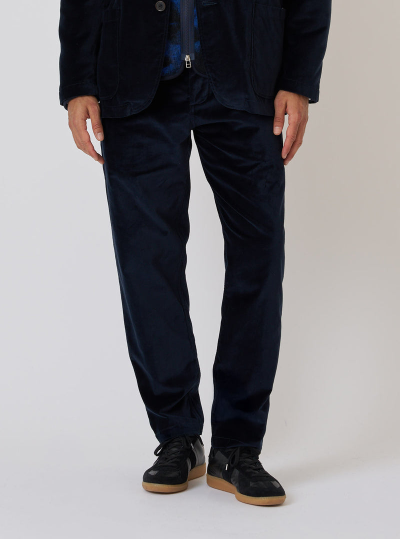 Close-up of a model wearing the Navy Velveteen Military Chino. The pants are a rich navy color and have a relaxed fit. The background is a clean, light gray.