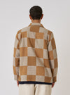 Back view of a model wearing the Sand Japanese Patchwork Easy Jacket. The jacket features a brown and beige checkerboard pattern. Shot against a white background.