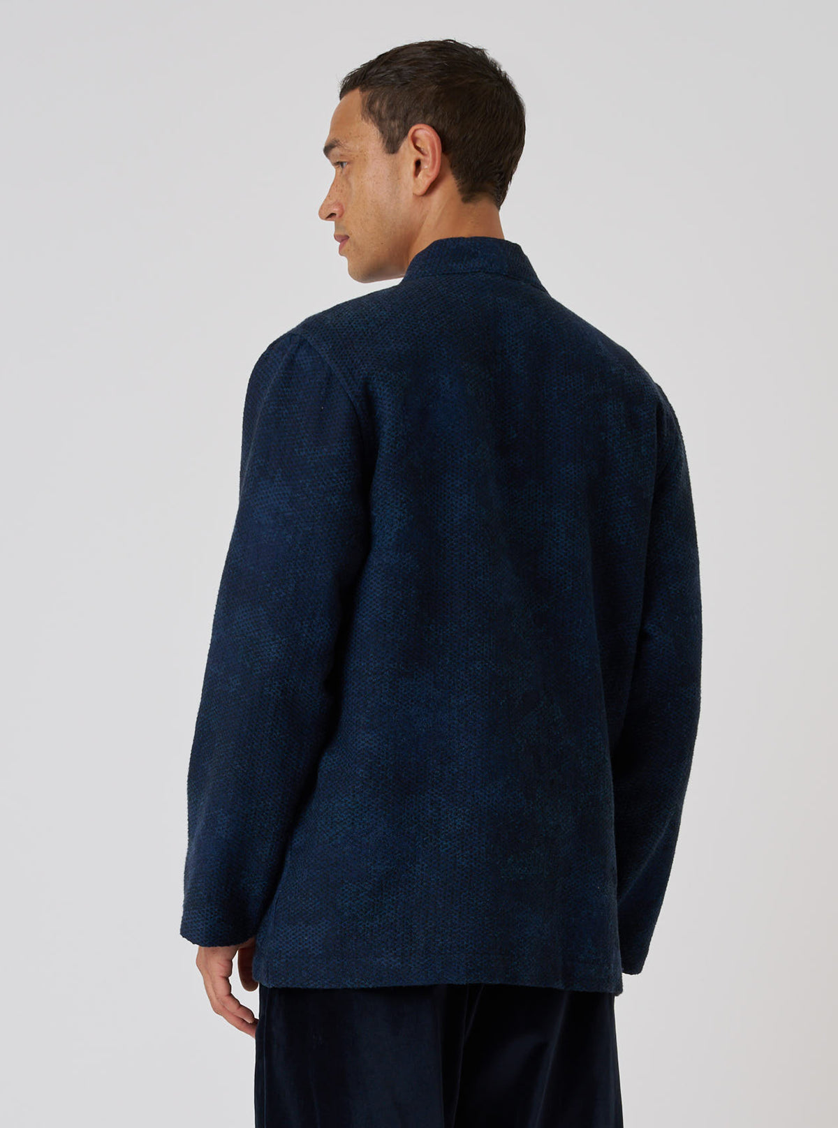 A man in a Black/Indigo Denim Camo Kyoto Work Jacket, back view, against a white backdrop. The jacket has a unique camo pattern and a relaxed fit.