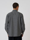 Back view of a model wearing a Charcoal Brushed Organic Cotton Square Pocket Shirt. The shirt is charcoal gray and made of organic cotton. The background is a plain white.