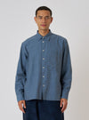 A model wears a Blue Brushed Marl Twill Square Pocket Shirt in front of a white background. The shirt is a light blue color with a square pocket.