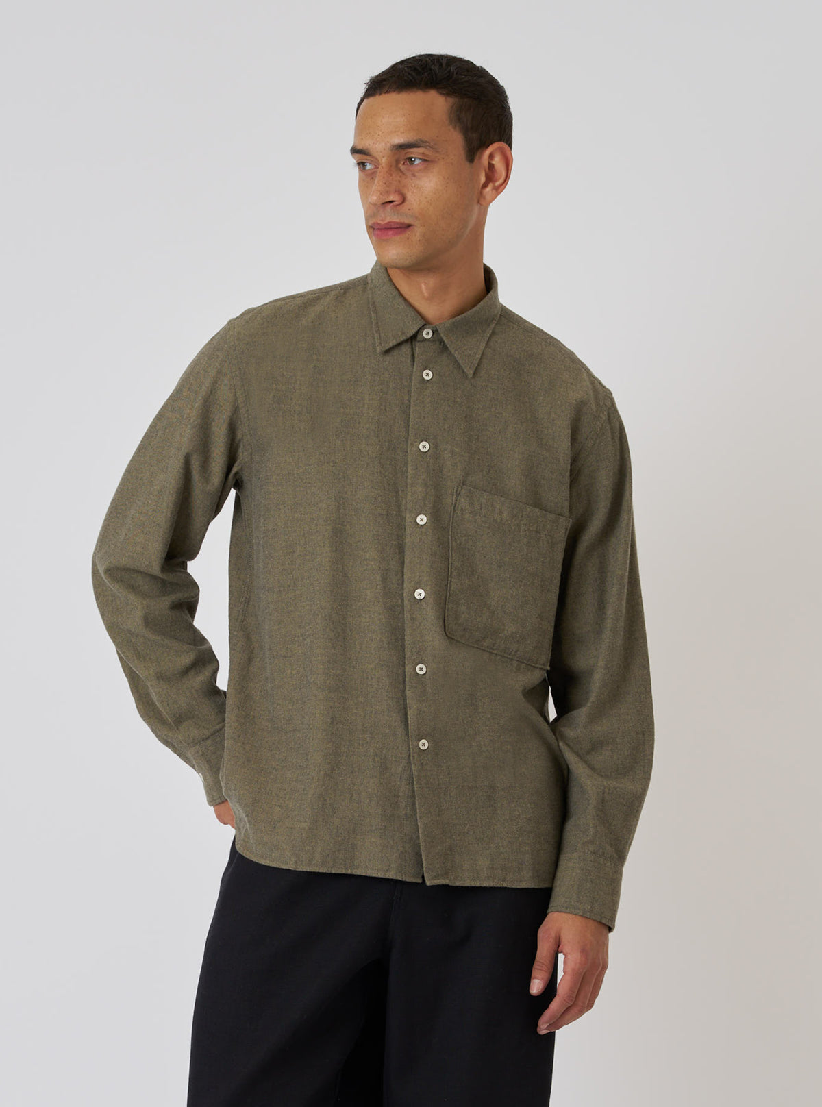 A model poses in a Mustard Brushed Marl Twill Square Pocket Shirt. The shirt is a textured mustard color with a square pocket. The background is a plain white backdrop.