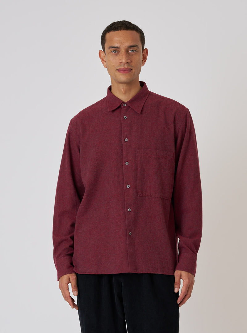 A model wears a Red Brushed Marl Twill Square Pocket Shirt against a white background. The shirt is buttoned and has a square pocket on the chest.
