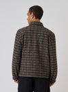 Back view of a model wearing a Brown Jacquard Knit Rams Jacket. The jacket has a brown and beige grid pattern. Shot against a plain white background.