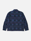 The Navy Madras Patchwork Duty Jacket is shown from the back, laid flat against a plain white background. The image highlights the patchwork construction of various blue and navy plaid cotton fabrics, the straight hem, and the loose, darted sleeves.